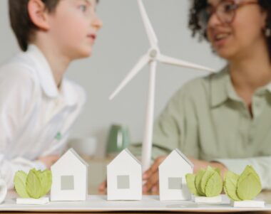 Childen behind house and windmill made of paper